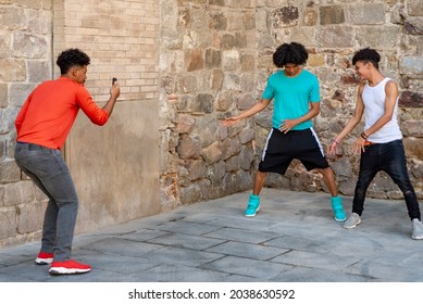 Afro Latin Male Teenager Friends Dancing In The Street And Recording It With The Mobile Phone. Copy Space