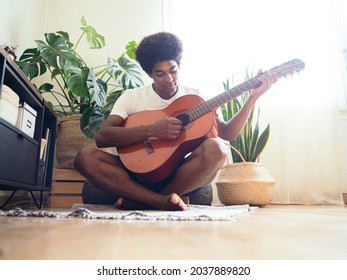 Afro Man Playing A Acoustic Guitar In A Modern Apartment	