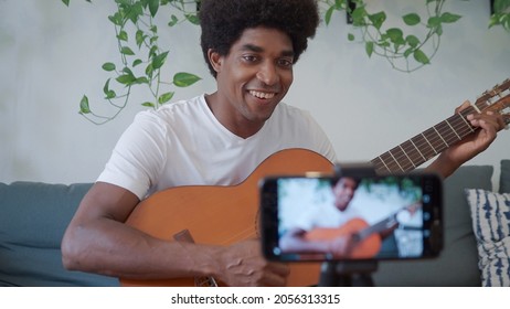 Afro Man Recording Himself With The Mobile While Playing The Guitar.Focus On Man