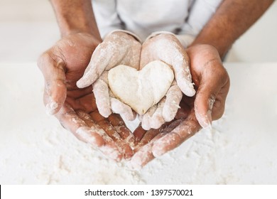 Afro man's hands holding childs hands with heart shaped pastry. Happy childhood concept - Powered by Shutterstock