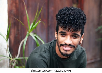 Afro Smiling Man Portrait. African-American Youth Millenial With Natural Curly Hair Looking At Camera. Mixed Race Young With Beard And Earring. Multiracial People And Diversity Concept.