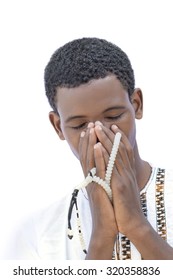 Afro teenager praying with rosary beads, isolated 