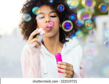 Afro Woman Blowing Soap Bubbles 