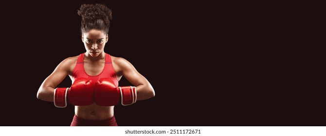 Afro woman in red boxing gloves professional boxer posing over black studio background - Powered by Shutterstock