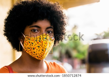 afro woman using colorful face mask outdoor, corona virus protection concept. copy space.