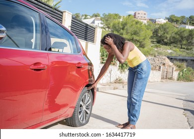 Afro Woman Very Worried About A Flat Tire On Her Red Car