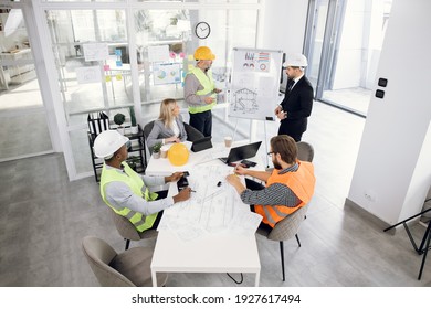 Afro-american and caucasian business partners sitting at office during working conference. Competent architects,designers and engineers discussing creative and modern ideas of construction. - Powered by Shutterstock