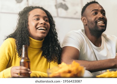 Afro-american Couple Smiling And Drinking Beer At Home