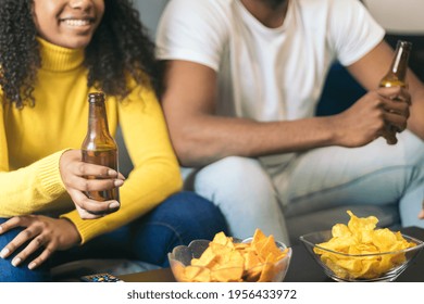 Afro-american Couple Smiling And Drinking Beer At Home