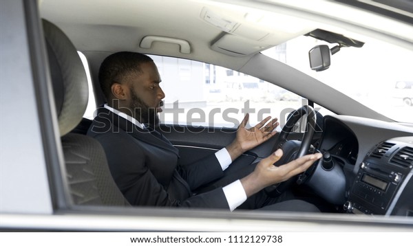 Afro-American man getting angry and nervous\
because of car breakdown,\
stress