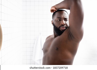 Afro-american Man Putting Hand Up And Smelling Armpit