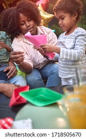 Afro-american Mother Teaching Daughter How To Make Paper Boat. Family Value, Togetherness