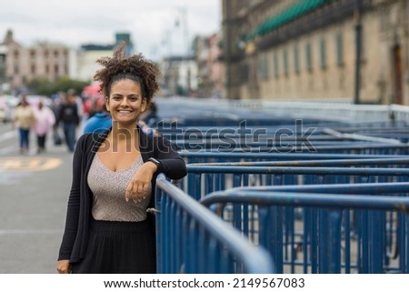 Afro-descendant girl smiling next to National Palace railings in Mexico City, CDMX, Mexico