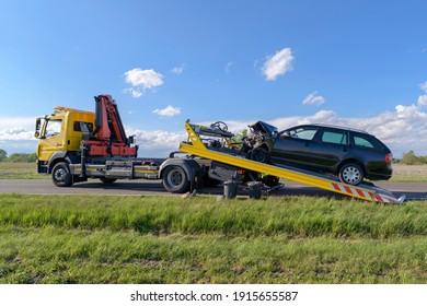 After an accident the crashed car is pulled onto a tow truck - Shutterstock ID 1915655587