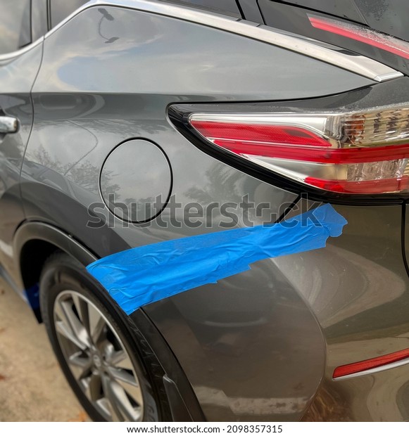 After the accident put blue adhesive\
tape on bumper and vehicle body. at the parking\
lot.