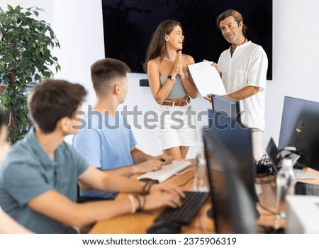 After completing course of computer literacy classes and general training, man teacher hands over trial certificate to best female student