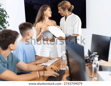 After completing course of computer literacy classes and general training, man teacher hands over trial certificate to best female student