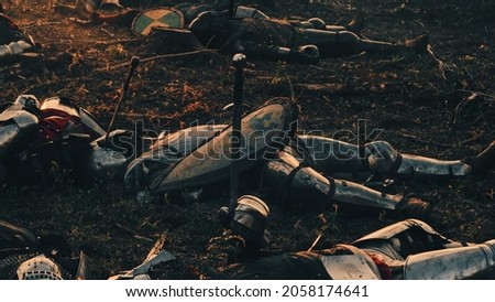 After Epic Battle Bodies of Dead and Killed Medieval Knights Lying on Battlefield. Warrior Soldiers Fallen in Conflict, War, Conquest, Crusade. Cinematic Dramatic Historical Reenactment.