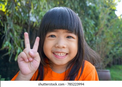 After Haircut, 4 Years Old Asian Cute Girl Counting Number Two By Fingers. Education Or Toddler Development Concept. Happy Learning.