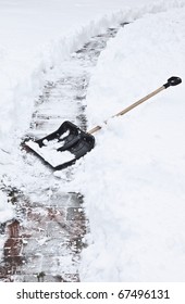 After A Heavy Snowstorm. Black Shovel To Remove The Snow From The Garden Path.