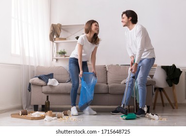 After Party. Smiling Young Couple Cleaning Mess After Gathering With Friends At Home, Copy Space