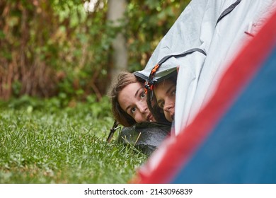 After rain young women peeking out of the tent - Powered by Shutterstock