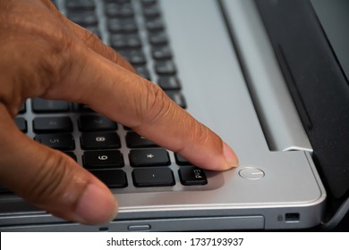 After Saving All Work A Man Use Finger To Press The Button To Turn Off Silver Notebook Computer, Which Is Placed On The Desk And Is The Time To Finish Each Day Before Going Home, Close Up, Electronics