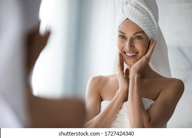 After Shower Body And Head Wrapped In Towel 35s Woman Looks In Mirror Touches Moisturized Soft Healthy Face Skin Feels Satisfied Enjoy Spa Cosmetics Treatment Procedure, Morning Care Hygiene Concept