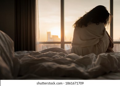 After sleepless night sad woman got up sit on bed thinking, lost in sad thoughts about irreparable mistake decision, feeling remorse, break up in relations with beautiful sunlight in the morning.