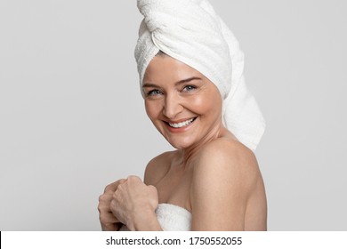 After Spa. Portrait Of Happy Beautiful Mature Woman With Towel On Head Smiling At Camera, Posing In Bathroom Afrer Beauty Treatments, Free Space