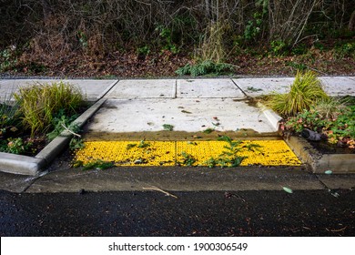 After The Storm, Floodwater And Storm Debris On A Sidewalk Disabled Curb Ramp On A Sunny Day
