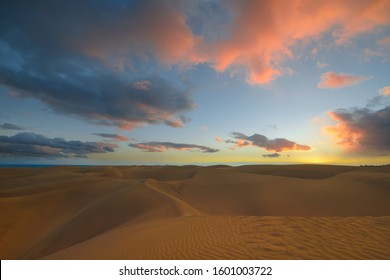 After Sunset in the desert, Beautiful blue sky and fluffy pink blue clouds. Fine, golden sand of the dunes of the desert in Maspalomas, Gran Canaria at Canary islands, Spain