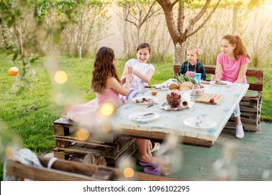 After They Finished Meat From The Stick , Two Playful Girls Are Having A Sword Fight With Sticks While Their Older Sister And Toddler Brother Are Watching Them.