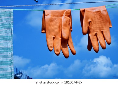 After wash use red gloves, hanging gloves with blue sky for protecting by corona virus