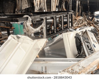 The aftermath of a severe fire has left industrial machinery and building structures in a state of complete disarray and ruin