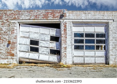 Aftermath of tornado - Commercial garage doors in vintage brick building - one is wrecked and mangled while one is still intact