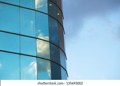 Afternoon cloudy sky reflecting off an office building's curtain wall.