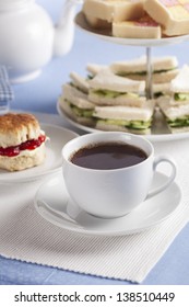 Afternoon Cup Of Tea With Cucumber Sandwiches And Scones In The Background.