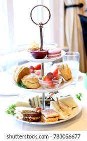 Afternoon High Tea With A Tiered Tray Of Decadent Sandwiches, Scones And Desserts