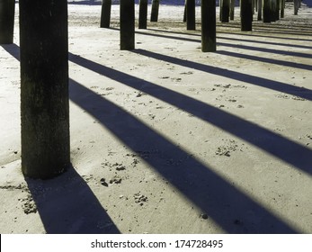 Afternoon shadows of pylons under long pier at Fernandina Beach, Florida - Shutterstock ID 174728495