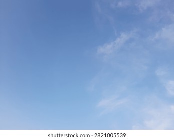 Afternoon sky with sparse clouds.