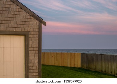 An Afternoon Sunset On Nantucket Island Of The Coast Of Cape Cod, Massachusetts. A Calming Pastel Sky Over The Atlantic Ocean, Seen Behind The Classic East Coast Home.