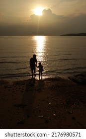 The Afternoon View When The Sun Is About To Set A Mother And Daughter Who Are Having Fun Playing On The Pingiran Beach Of The Seaside Port In Tanjungpinang City