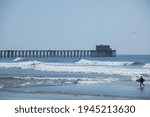 Afternoon waves crash into the historic municipal pier at Oceanside, California, USA.