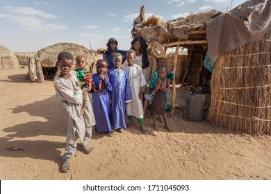 Agadez, Niger - September 2013: African  Family Djerba Tribe In Traditional Colorful Clothes In Front Of Their House In Sahara Desert On The Boarder Of Niger And Algeria 