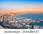Agadir, Morocco at sunset. Panoramic view of Agadir city and bay in southern Morocco with Marina, beach and ocean from Oufla or Casbah fortress. Moroccan seaside resort on Atlantic coast in Africa.