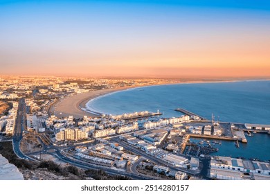Agadir, Morocco at sunset. Panoramic view of Agadir city and bay in southern Morocco with Marina, beach and ocean from Oufla or Casbah fortress. Moroccan seaside resort on Atlantic coast in Africa.