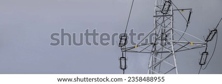 Against the background of an overcast sky stands a high-voltage electric pole.