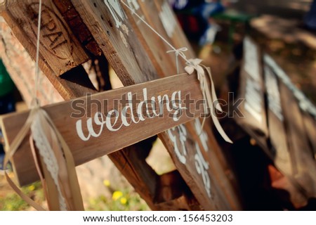 against the background of shelves wooden signboard with the inscription in white paint wedding