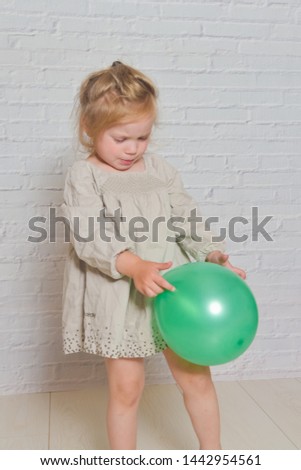 the against a white brick wall sad girl with a green balloon